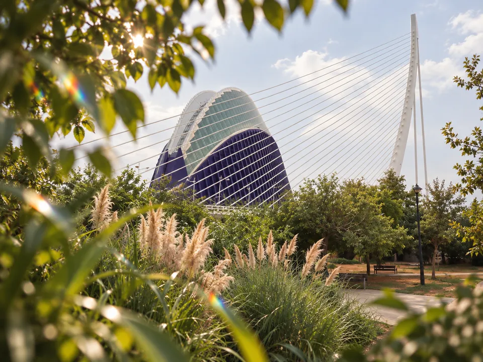 AI-generated illustration: CaixaForum València exterior with garden leaves and subtle refracted light suggesting Forest Optics.