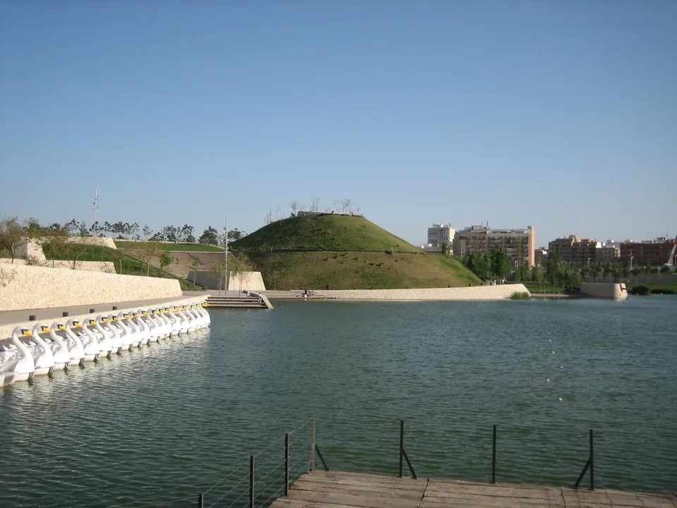 Lake, pedal boats and landscaped hill in Parque de Cabecera, Valencia.